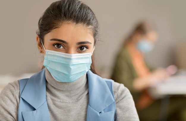 Ritratto di donna con maschera facciale in ufficio