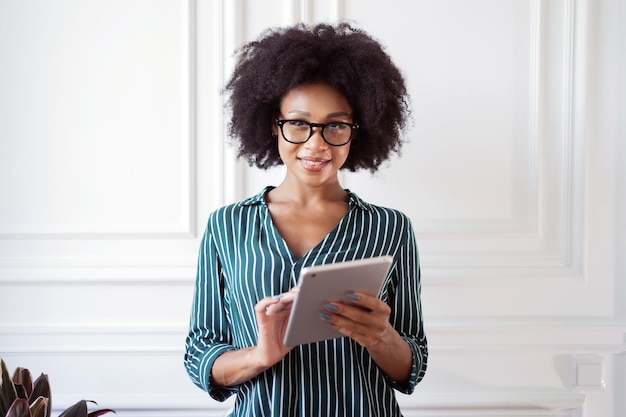 Portrait of a woman with glasses working in an office looking at the camera smiling