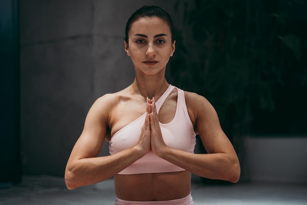 Photo portrait of woman with hands clasped exercising at gym