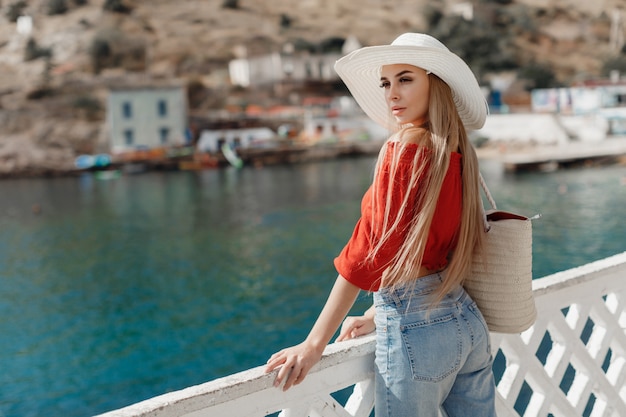 Foto ritratto di una donna con cappello in piedi vicino al mare