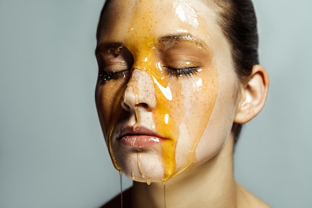 Portrait of woman with honey on her face
