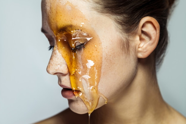 Foto ritratto di donna con miele sul viso