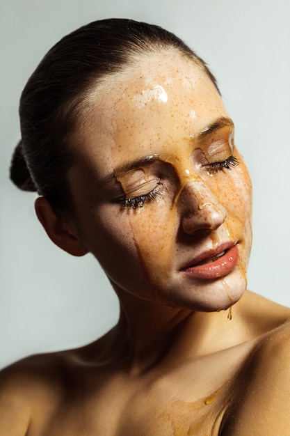 Portrait of woman with honey on her face