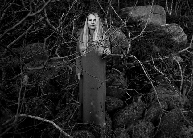 Foto ritratto di una donna con i capelli lunghi in piedi nella foresta