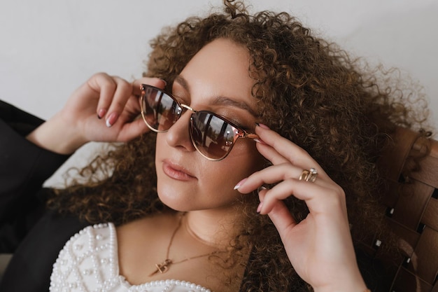 Portrait of a woman with lush hair holding glasses