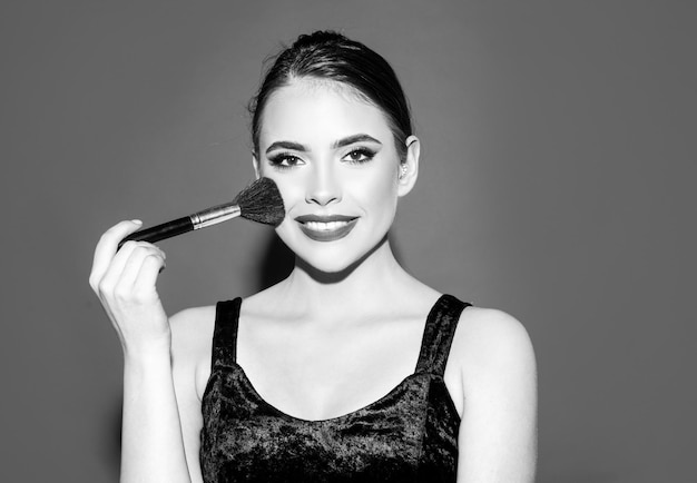 Portrait of woman with makeup brush near face Woman beauty face portrait of beautiful female model S...