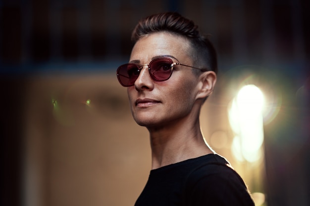 Portrait of woman with mohawk hairstyle standing in front of the building entrance