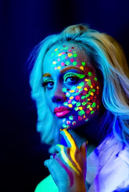Portrait of a woman with painted face woman with uv makeup in studio portrait of a woman