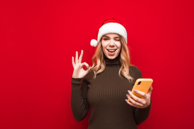 portrait woman with santa hat holding phone