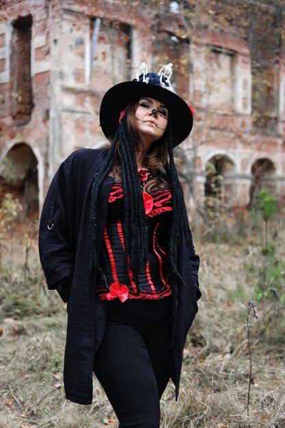 Photo portrait of a woman with a skull makeup dressed in corset cardigan and a tophat baron saturday