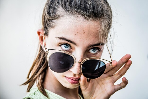 Portrait of woman with sunglasses against white background