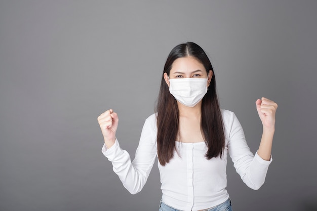 Portrait of woman with surgical mask in studio