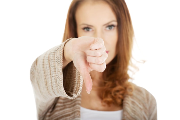 Portrait of woman with thumbs down against white background