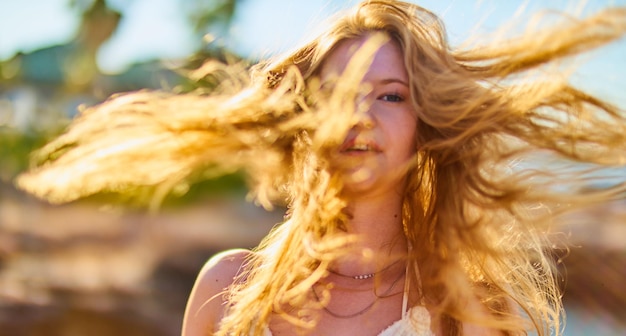 Portrait of woman with tousled hair in sunny day