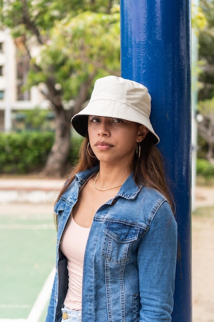 Portrait of woman would be leaning against a pole