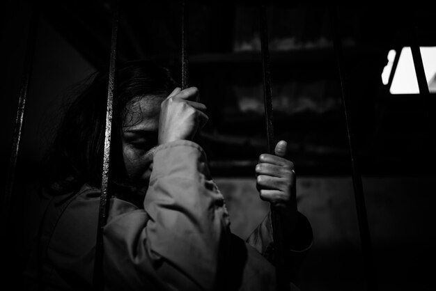 Portrait of women desperate to catch the iron prisonprisoner conceptthailand peopleHope to be freeIf the violate the law would be arrested and jailed