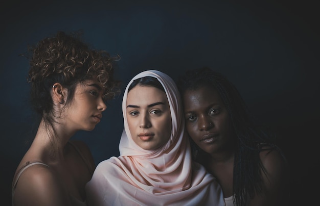 Foto ritratto di donne che si abbracciano in piedi su uno sfondo nero