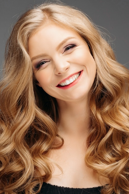 Portrait of wonderful young blonde woman with long hair, smiling