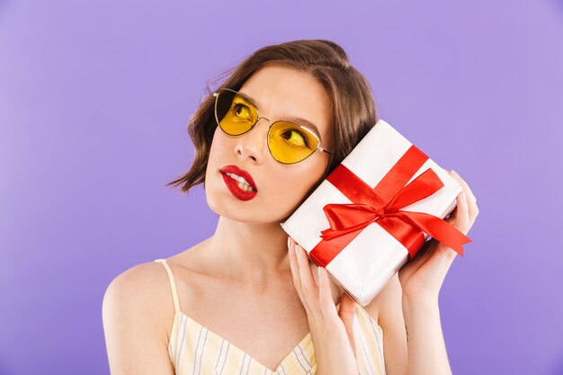 Portrait of a wondering young woman in sunglasses