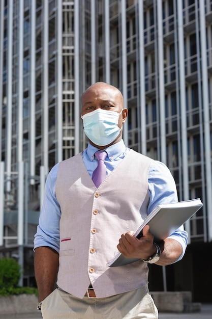 Photo portrait of a worker black man with a notebook in his hand.