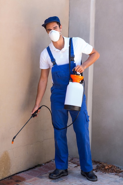 Портрет работника, распыления химикатов на стене