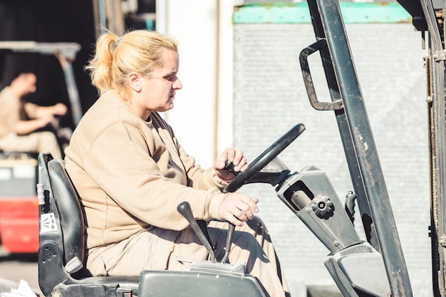 Portrait of a working woman driving a forklift