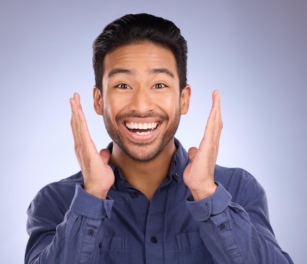 Portrait wow and Asian man with smile surprise and excited with happy guy against blue studio background Face male and gentleman with happiness shocked for good news success and announcement