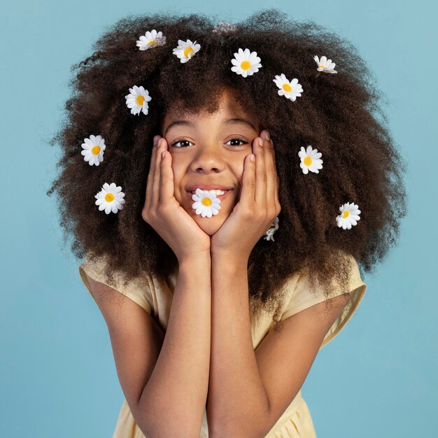 Portrait of young adorable girl posing with chamomile flowers