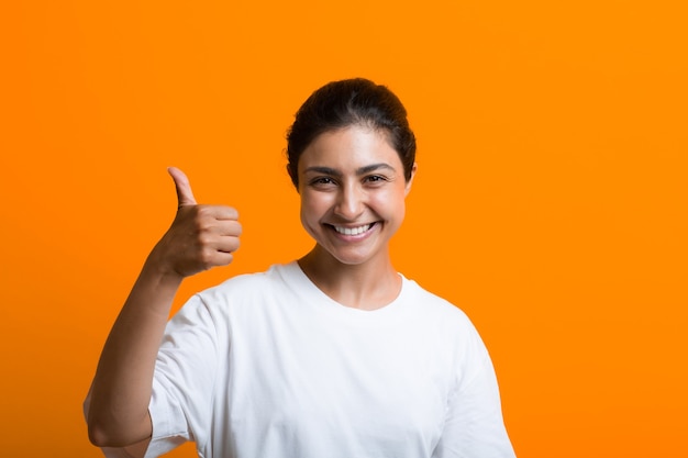 Portrait of young adult indian woman with thumbs up sign gesture