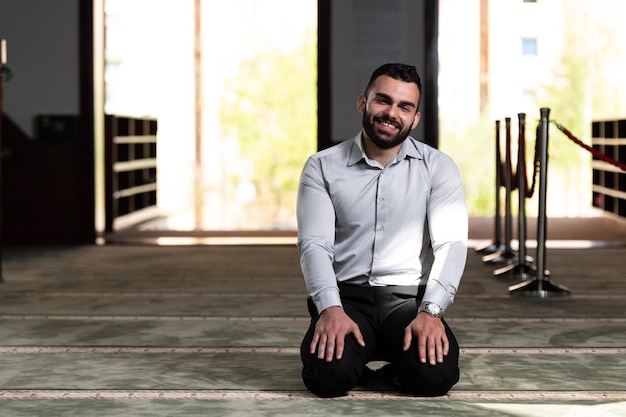 Portrait of a young adult muslim man is praying in the mosque