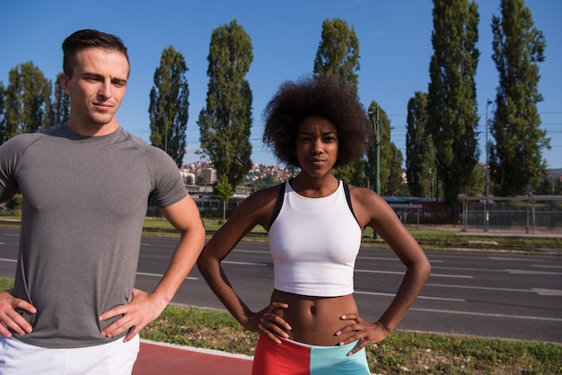 Foto ritratto di una giovane bella donna afroamericana e di un giovane che fa jogging in città