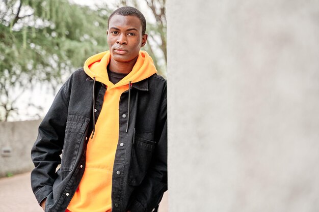 portrait of young african american man standing outside by white wall in a city copy space for text