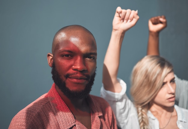 Photo portrait of young african american man standing together with protesters holding fists showing strong striking gesture in support social justice human rights issues movement stands in unity