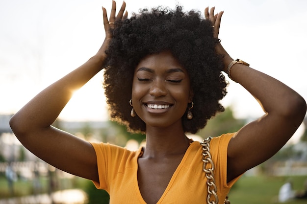 Ritratto di una giovane donna afroamericana sorridente in piedi in città