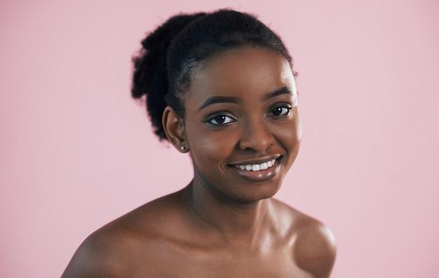 Portrait of young african american woman that is against pink\
background