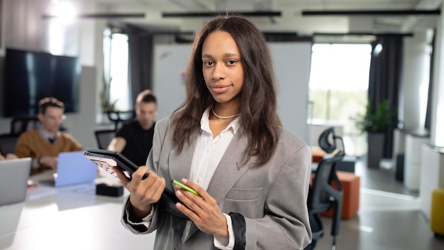 Portrait of a young african american woman with a laptop in her hands on the background of the office