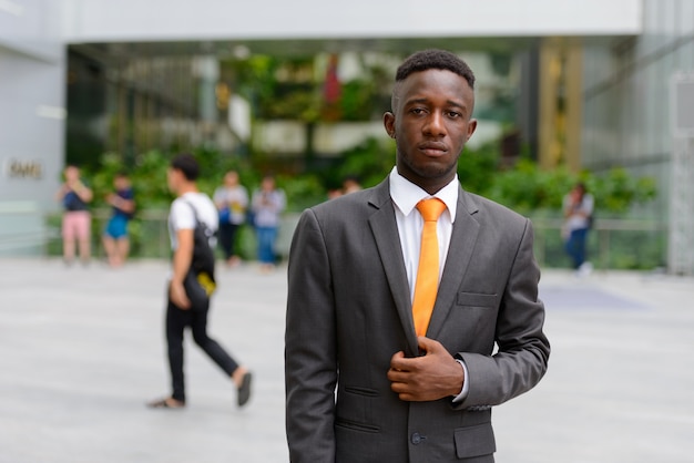 Ritratto di giovane uomo d'affari africano nella città all'aperto