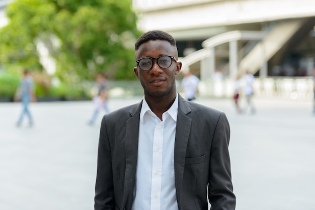 Portrait of young African businessman in the city outdoors