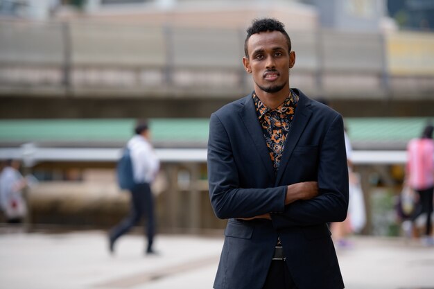 Portrait of young African businessman in the city streets outdoors