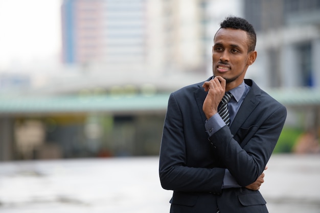 Portrait of young African businessman in the city streets outdoors