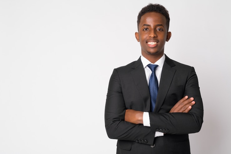 Photo portrait of young african businessman with afro hair in suit against white wall
