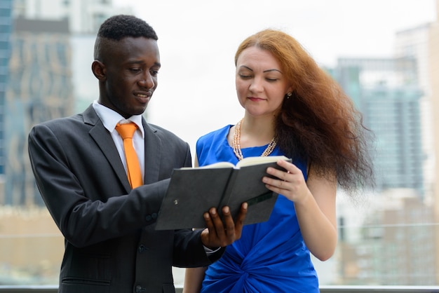 Portrait of young African businessman and young businesswoman with red hair together