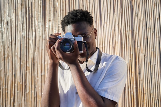 portrait of a young african man holding a vintage camera