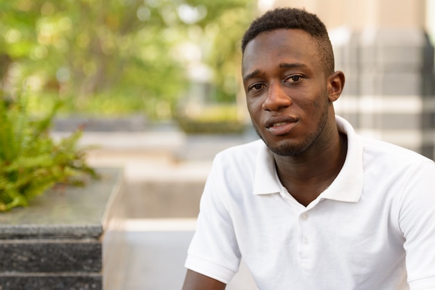 Portrait of young African man at modern building in the city outdoors