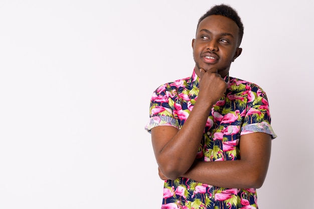 Portrait of young African tourist man against white wall