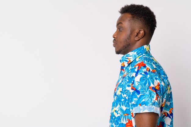 Portrait of young African tourist man against white wall