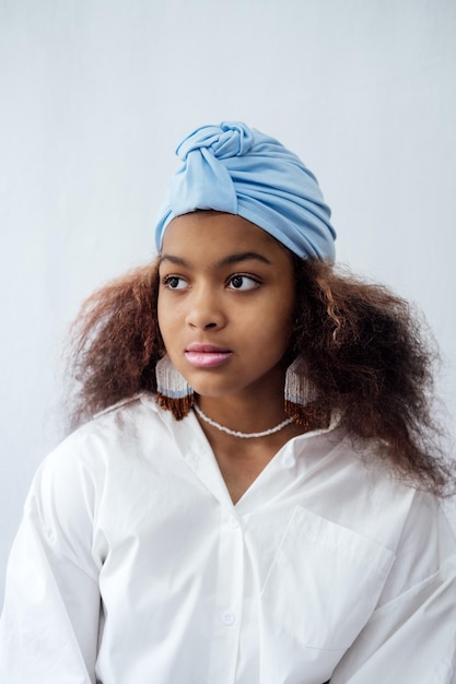 Portrait of young african woman with headscarf and ethnic jewelry african beautiful brunette curly