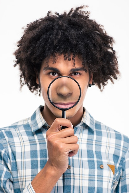 Photo portrait of a young afro american man holding magnifying glass isolated on a white wall