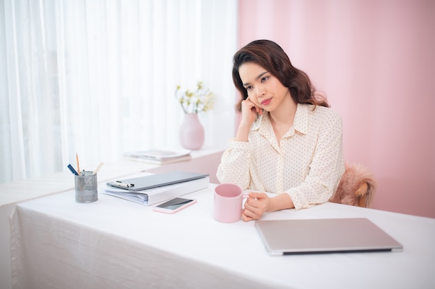 彼女のオフィスで疲れを感じている若いアジアのビジネス女性の肖像画。