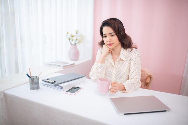 Portrait of young Asian business woman feeling tired at her office